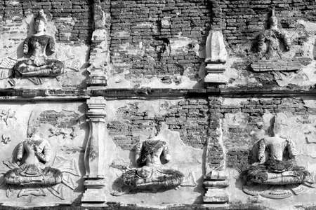Black and white Old stucco Buddha and angel figures on the outside of the Maha Chedi of Wat Chet Yot (Wat Jed Yod) ,Located in Chiang Mai, Thailand.の写真素材