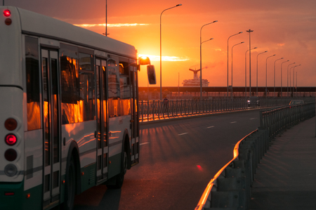 Passenger autobus on the background of the sunset and sea port in St. Petersburg. Russiaの写真素材