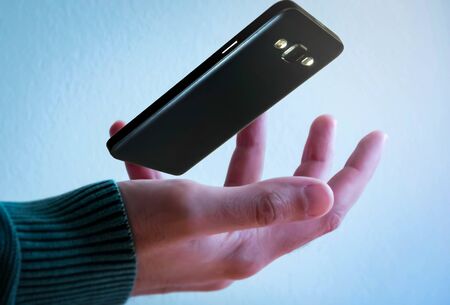 Mobile phone floating above handの写真素材