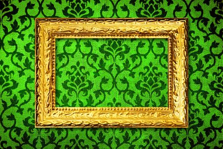 Gold frame on a vintage green wall backgroundの写真素材