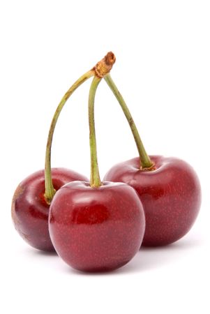 Three red cherries on a white backgroundの写真素材