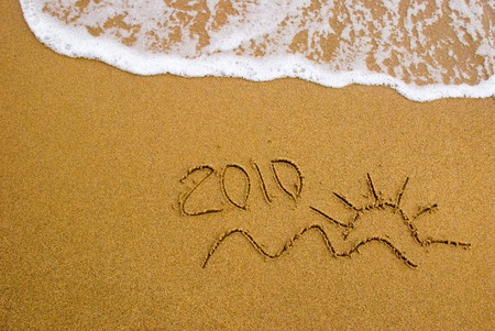 Year 2010 written on the sand