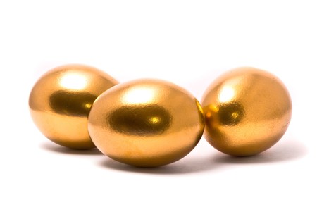 Three golden eggs on studio white backgroundの写真素材