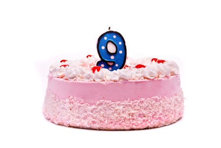 Pink cake with candle isolated on white backgroundの写真素材