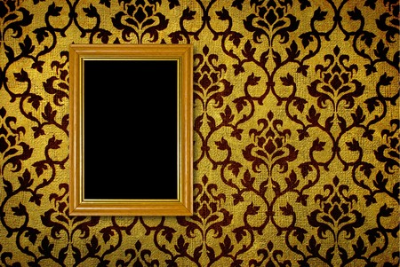 Gold frame on a vintage yellow wall background の写真素材