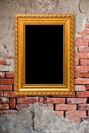 Gold frame on a old bricks wall backgroundの写真素材