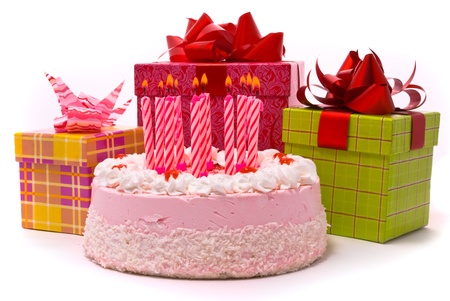 Pink pie with eleven candles and gifts in boxes on a white backgroundの写真素材