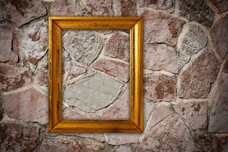 Gold frame on a old wall backgroundの写真素材
