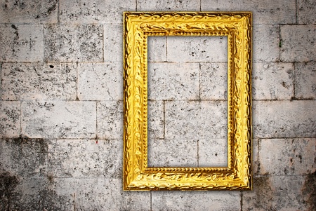 Gold frame on a old wall backgroundの写真素材