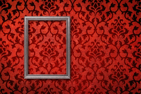 Silver frame on a vintage red wall backgroundの写真素材