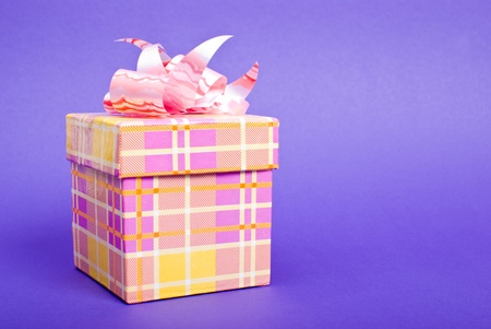Single yellow gift box with pink ribbon on blue background. の写真素材