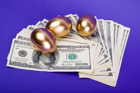 Golden eggs. A symbol of making money and successful investment on blue backgroundの写真素材