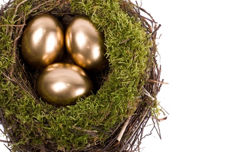 Three golden eggs in the nest isolated on white backgroundの写真素材