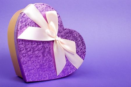 Single heart gift box with ribbon on blue background.の写真素材