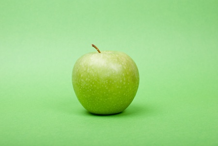 Ripe green apple on green backgroundの写真素材