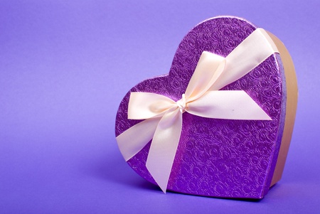 Single heart gift box with ribbon on blue background.の写真素材