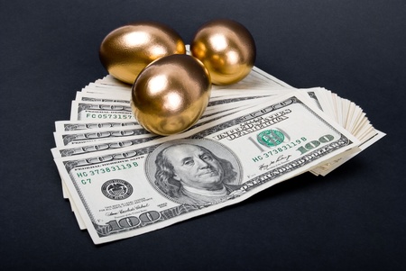 Golden eggs. A symbol of making money and successful investment on black backgroundの写真素材