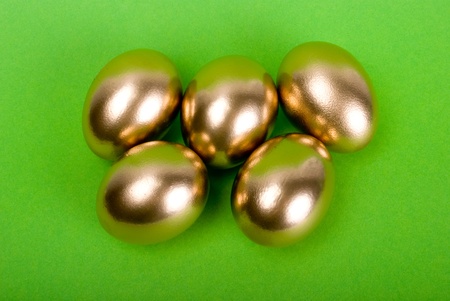 Golden eggs. A symbol of making money and successful investment on green backgroundの写真素材