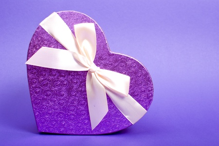 Single heart gift box with ribbon on blue background.の写真素材