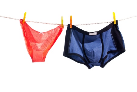 Red woman panties and blue man underwear on clothesline isolated on white backgroundの写真素材