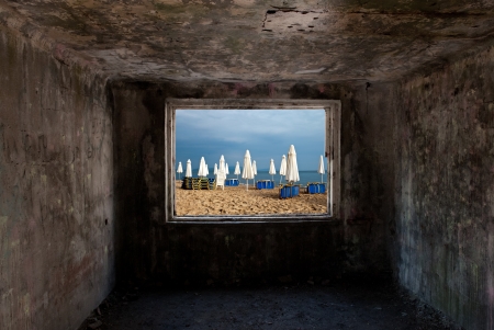 Dark old room with window with beach and sea behind himの写真素材