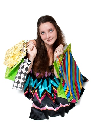 Young woman in dress with colorful shopping bags on a white backgroundの写真素材
