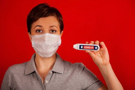 Coronavirus. The New Coronavirus COVID-19,  A woman in a mask on a red background with a coronavirus...