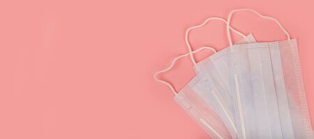 Medical mask for protection against flu and coronavirus on a pink background. Prevention of the...