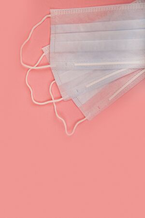 Medical mask for protection against flu and coronavirus on a pink background. Prevention of the spread of the virus and the pandemic COVID-19.の写真素材