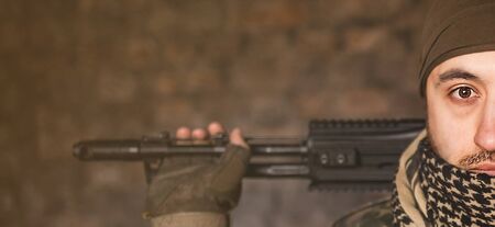 Arab male soldier in a headdress from the national keffiyeh with weapons in his hands. Muslim with firearmsの写真素材