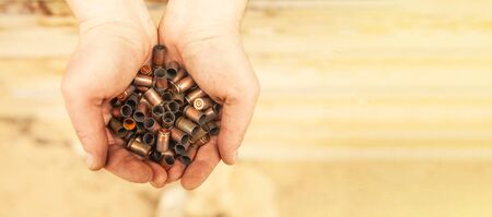 Cases after a shot from military cartridges in the hands of a soldier.の写真素材
