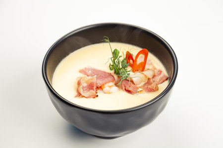 Pumpkin cream soup in black carriage. Ingredients pumpkin, cream, shrimp, seared bacon, honey, sesame oil, chili pepper, salt. For restaurant menu.の写真素材