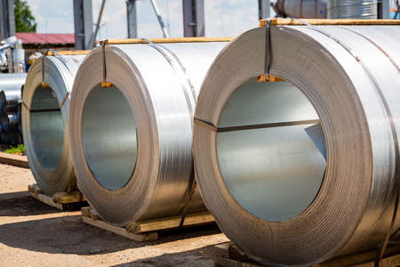 Stainless steel rolls. Rolls of steel sheet in the warehouse. A roll of galvanized steel sheet for the production of metal pipes and tubes in a factory.の写真素材