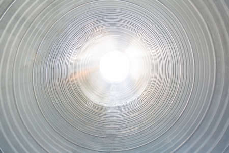 The ventilation pipe is round from the inside. Steel pipes, parts for the construction of industrial air conditioning ducts inside the pipe. Industrial ventilation equipmentの写真素材