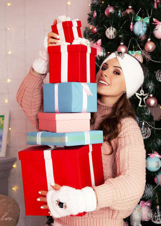 Smiling and happy, young woman in winter clothes holds many wrapの写真素材