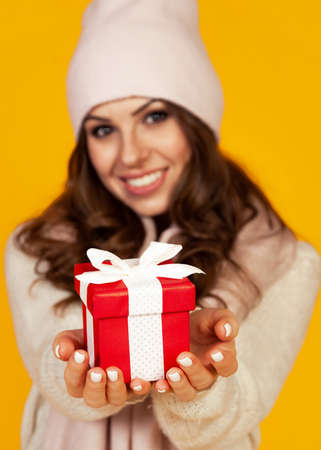 Happy young smiling woman holding and holding red gift box in frの写真素材