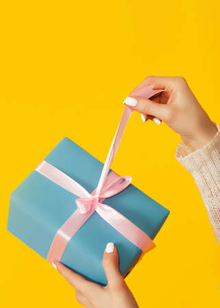 Happy young woman with open mouth opening a gift box of Christmaの写真素材