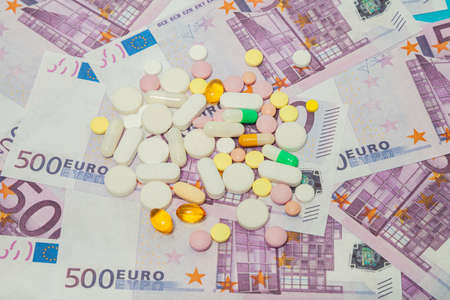 Money and pills. Pills of different colors on money. medicine concept. Euro cash. The rise in the cost of medical care. The concept of insurance medicine, insurance, high cost, high cost of drugs.の写真素材