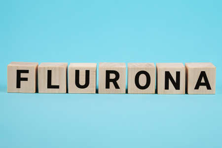 Covid-19 corona and the symbol flu flurona. Wooden cube concept word flurona on blue background....