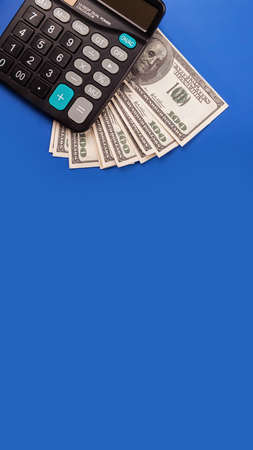 Money and calculator calculation. USD banknotes and a calculatorの写真素材