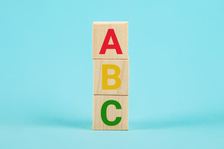 ABC on wooden blocks. ABC letters alphabet on wooden cube blocks in pillar form on blue background. Learn foreign languages. English for beginners. Copy the spaceの写真素材