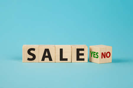 Sale word no to yes. Hand turns a dice and changes the word no to yes. On sale Cubes dice with Sale Yes or No on wooden backgroundの写真素材