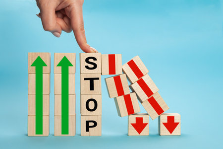Stop wording print on wooden block cube protect wooden falling domino for risk management concept.の写真素材