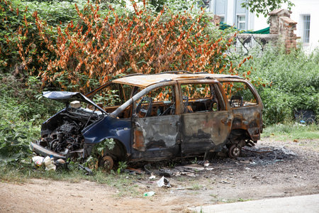 Car after a fire. Burnt rusty car after fire or accident. Car after the fire, crime of vandalism, riots. Arson car. Accident on the road due to speeding. Explosion.の写真素材