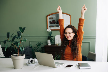 Young excited happy woman student winner success using computer laptop winning online at home, celebrating great exam results or new job opportunity receiving email with approval concept.