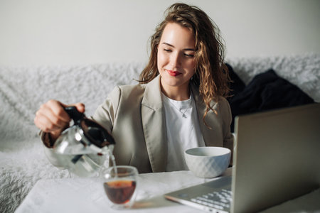 Healthy Breakfast with Laptop and Tea, Happy Girl Enjoying Morning Routine at Home, Nutrition and Technology, Productivity and Relaxation, Modern Lifestyle Conceptの写真素材