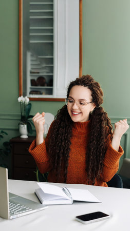 Happy Woman Winning Online: Receiving Good News via Email on Laptop. Excited Student Celebrating Success on Laptop Job Approval and Achievements Triumphant Student Winning Job Approval Overjoyed Womanの写真素材