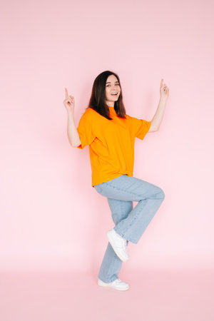 Triumphant Achievement: Beautiful Young Woman Celebrating Contract Success with Raised Fists, Commemorating a Major Sales Promotion - Vibrant Pink Backgroundの写真素材