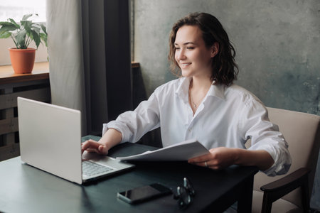 Flexible Work and Study: Young Woman Using Laptop at Office and Student Girl Working from Home. Freelancing, Business, and Lifestyle Concept.の写真素材