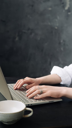 Young Woman Balancing Work and Study: Laptop Use at Home Office, Freelance, Business, Lifestyle Concept. Young Woman Engaged in Office Work on Laptop: WFH and Freelance Lifestyleの写真素材